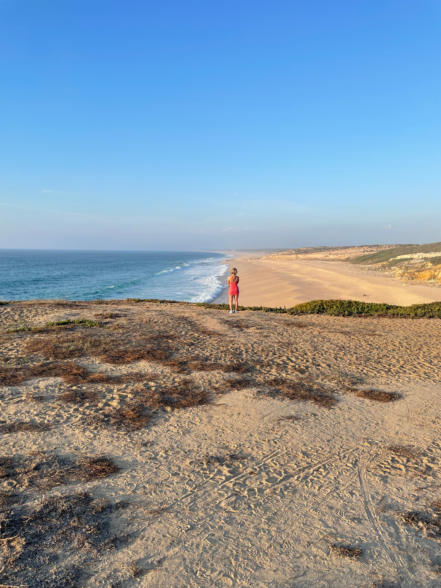 Woman walking on the beach at golden hour